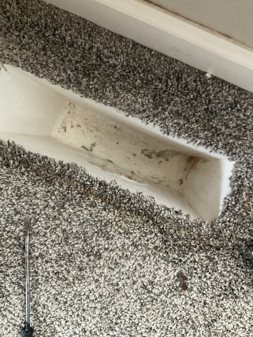 Air duct during cleaning, with visible dust and debris being removed.