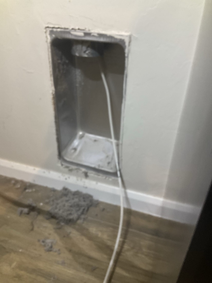 Interior electrical outlet box with dryer vent pipe attached to wall
