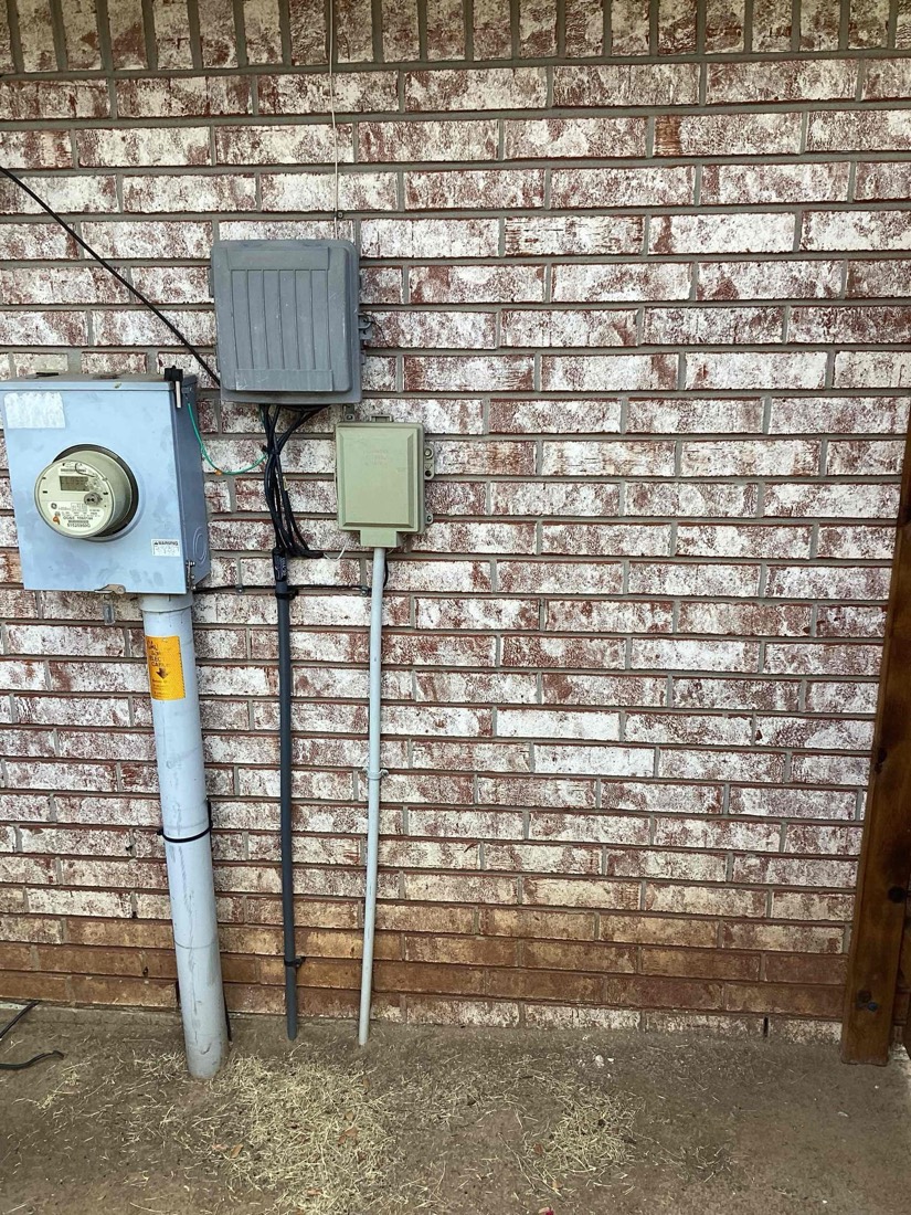 Installed electrical meter and service disconnect on brick wall.
