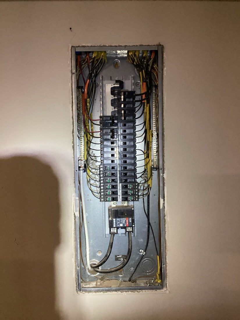 Newly installed electrical panel with organized wiring and circuit breakers