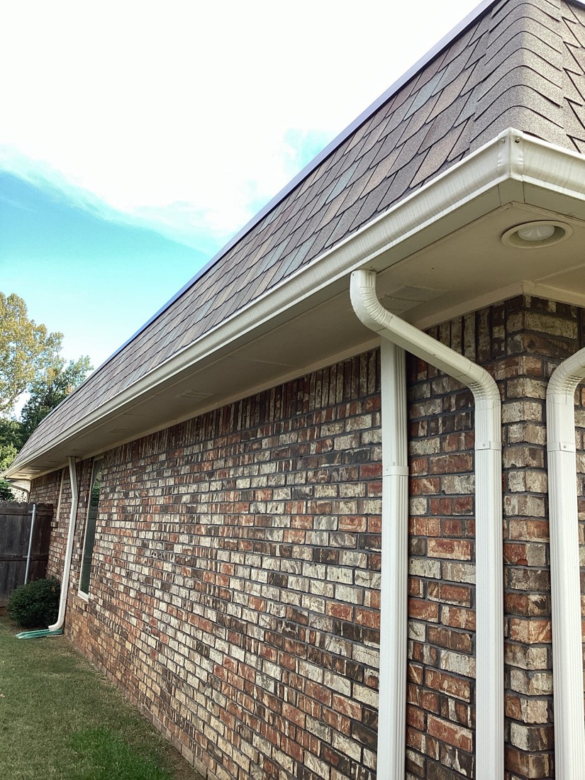 New gutters and soffit trim installation on brick home