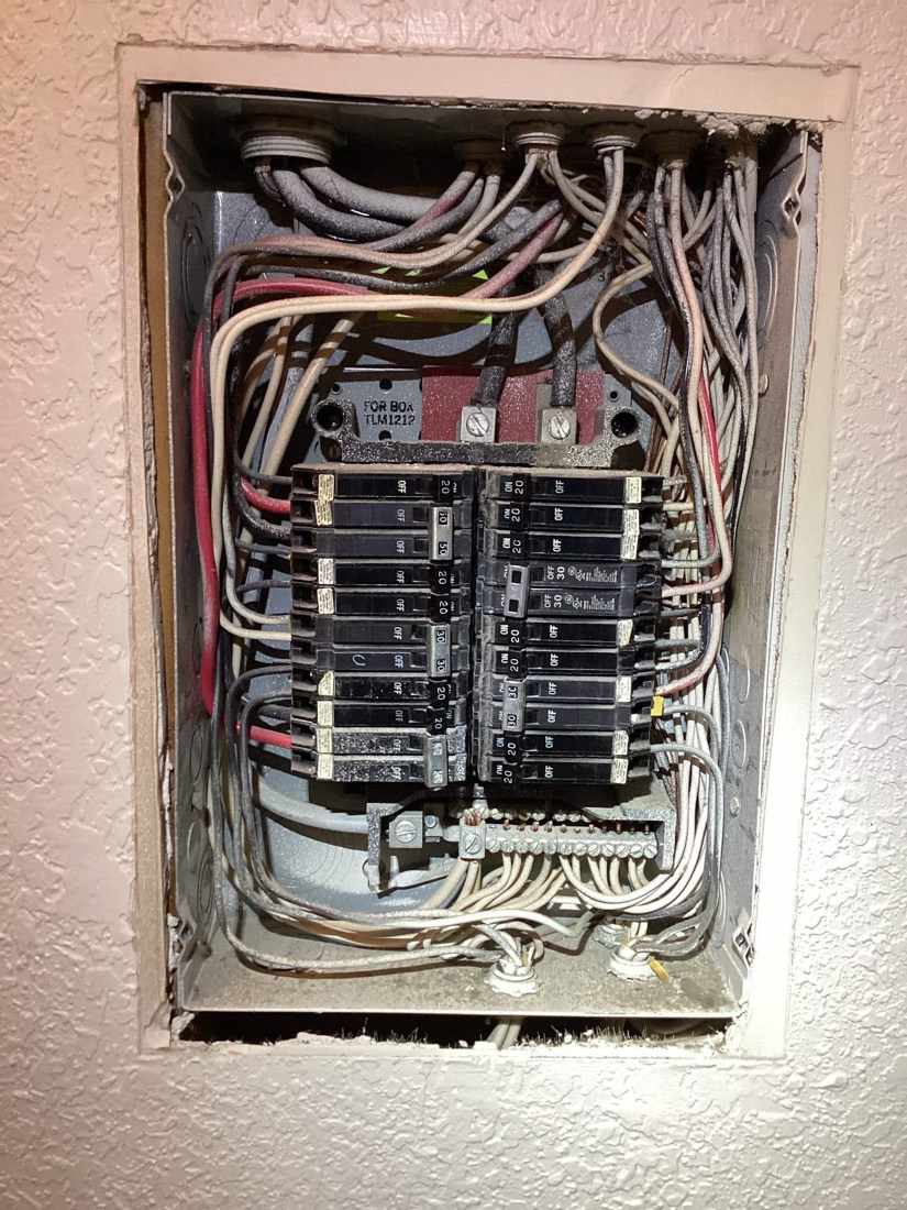 Fully installed electrical breaker panel with organized wiring.