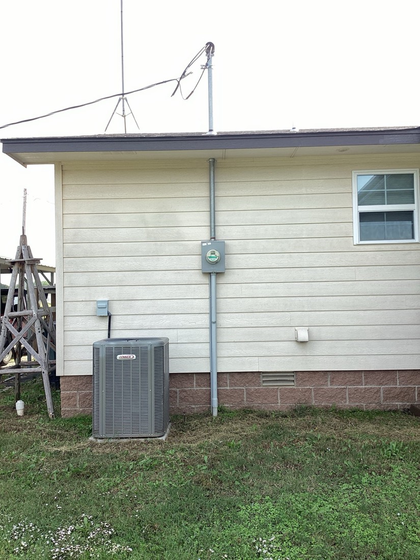 AC unit and electrical service installation on home exterior.
