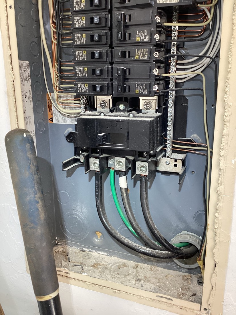 Electrical service entrance with main breakers and properly secured conductors.