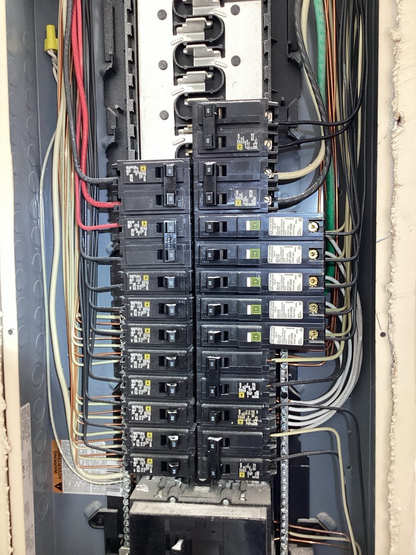 Main electrical panel with organized wiring and multiple circuit breakers.