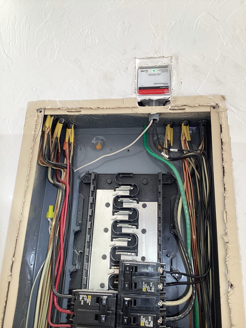 Electrical panel with organized color-coded wiring and multiple breakers.
