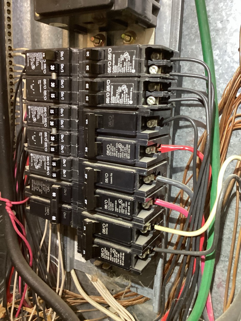 Upgraded breaker panel with neatly organized black breakers and red, yellow, and copper wiring.