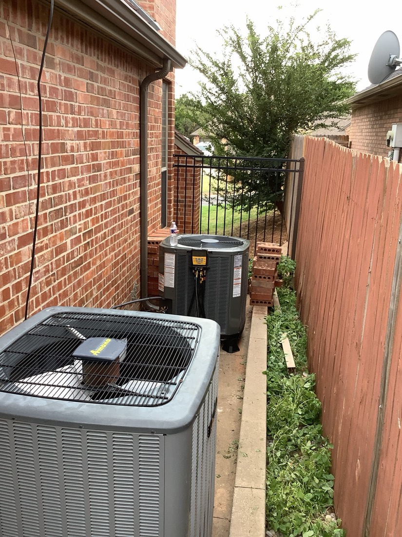 New AC condenser and furnace units installed outdoors on brick patio.
